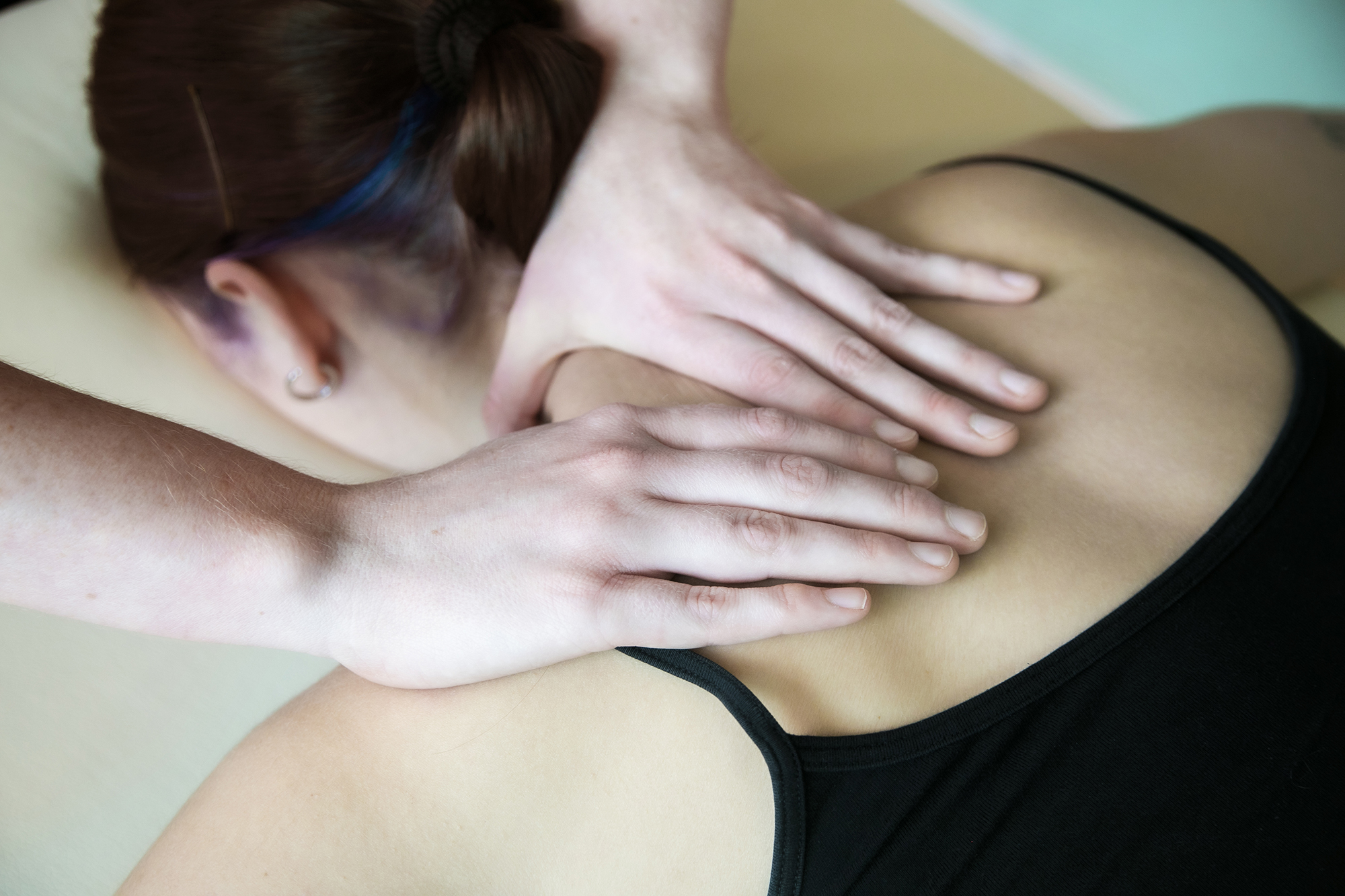 Close up of healthcare practitioners hands massaging dancers sholder